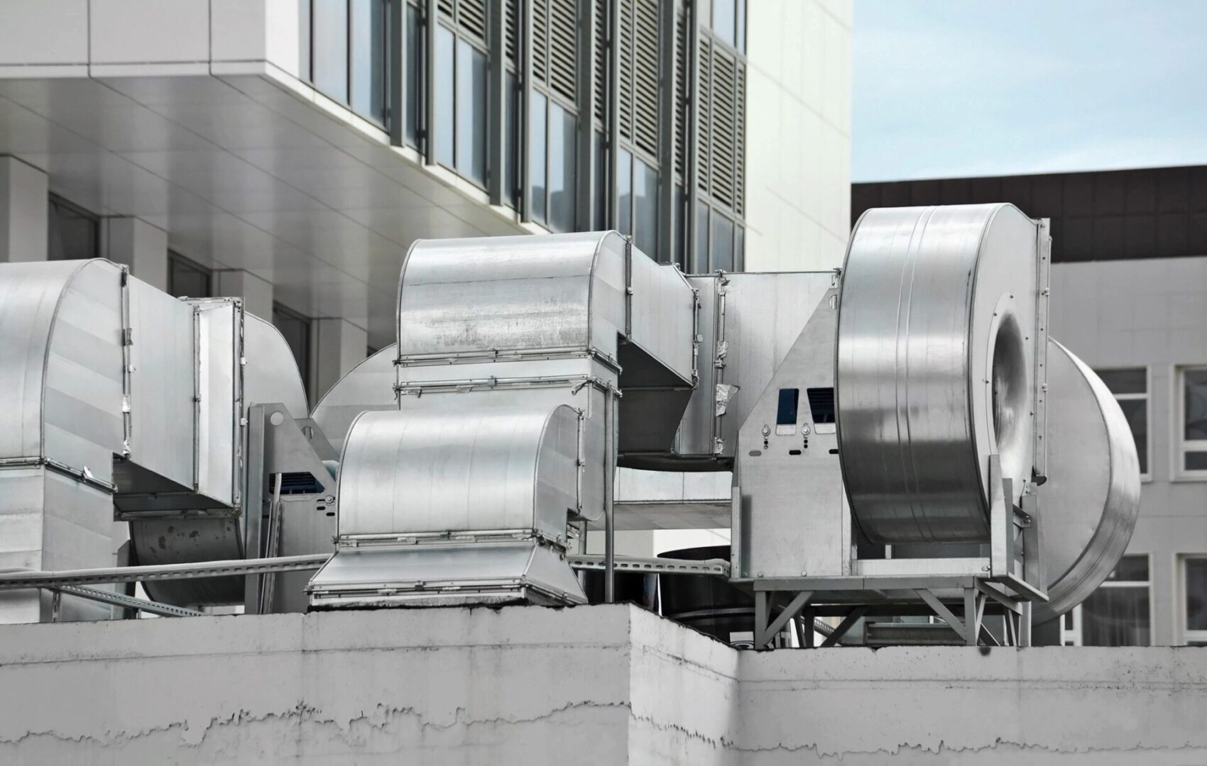 Industrial air conditioning units and ventilation systems installed on the rooftop of an urban building.